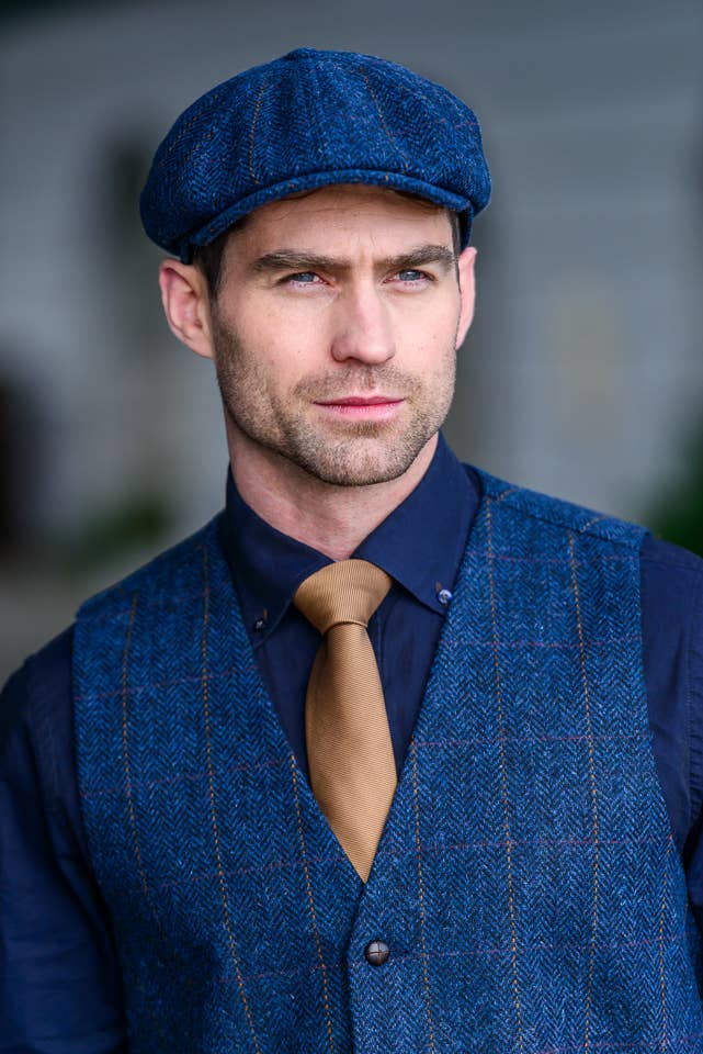 Man wearing a Navy herringbone 8 panel also called an Ivy cap. It is the style worn in Peaky Blinders. Sold in London, Ontario