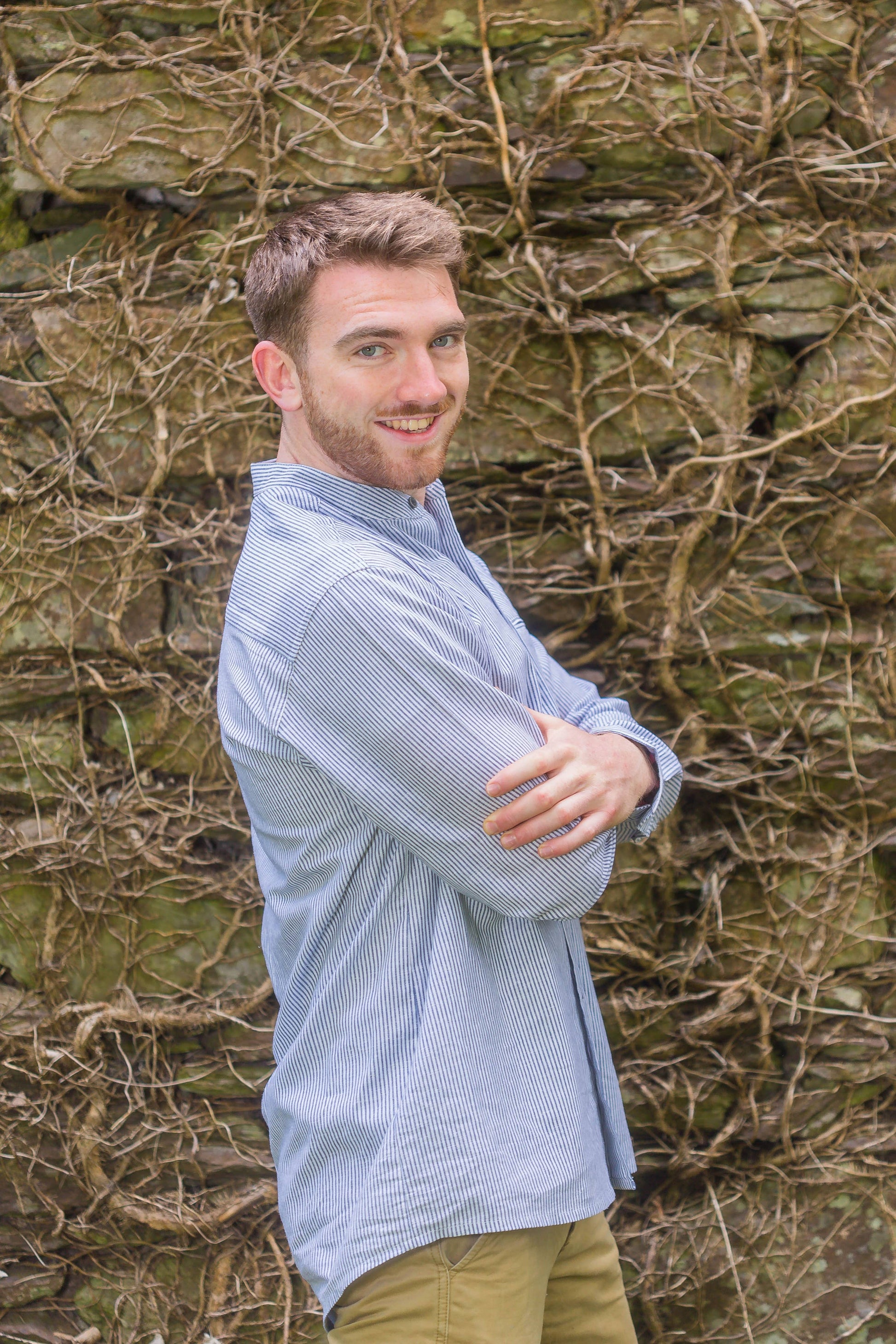 Blue and white striped linen shirt with a stand collar, sold in London, Ontario, shown on an Irish bloke leaning on a wall. Shirt is for men or women.