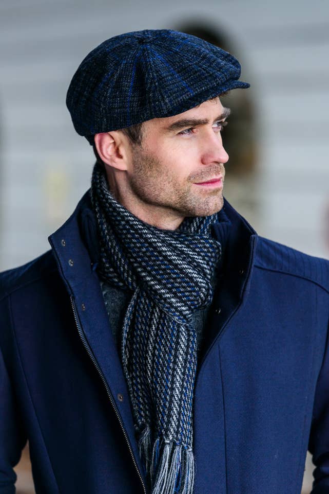 Man wearing a charcoal, black and royal check 8 panel also called an Ivy cap. It is the style worn in Peaky Blinders. Sold in London, Ontario