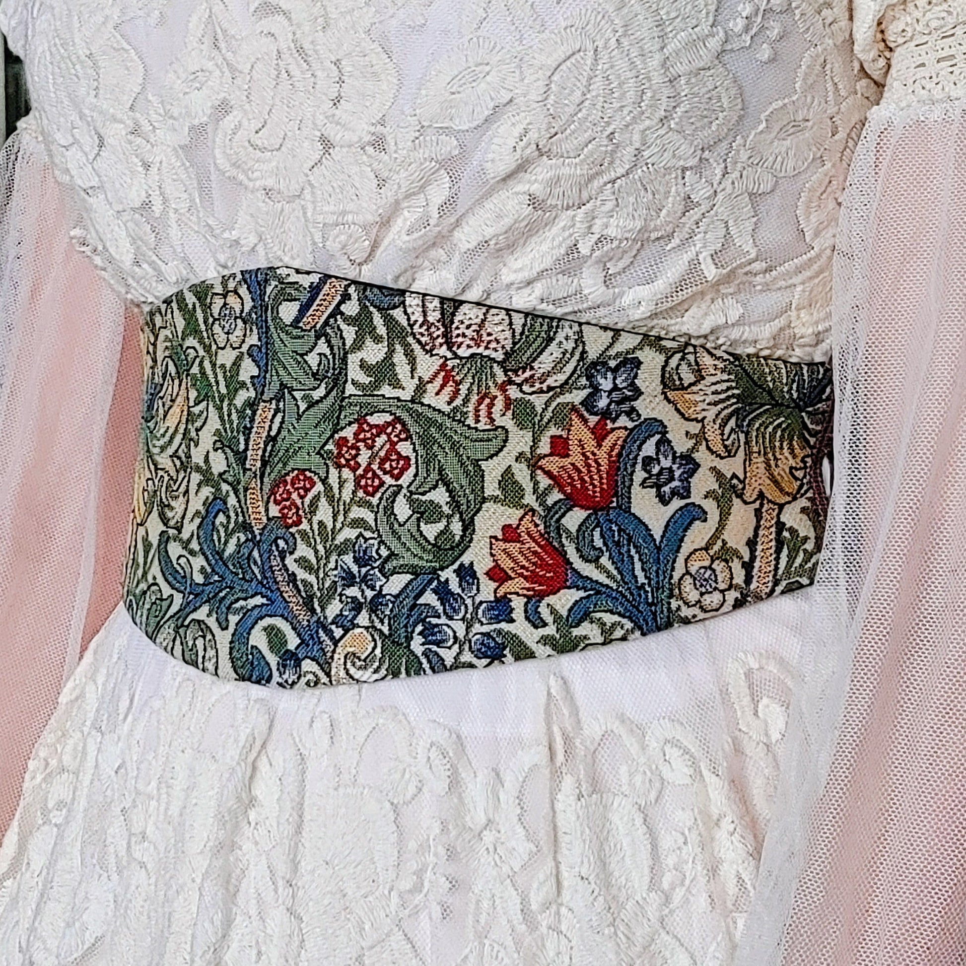 Tapestry Corset belt by Plumage Studio Accessories shown worn over a white lace dress